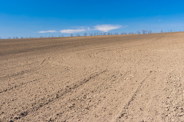 Fototapeta na wymiar Spring landscape with soil prepared for crops sowing near Dnipro city, Ukraine