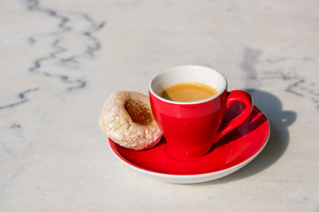 Rote Espressotasse auf weißem Bistrotisch aus Marmor