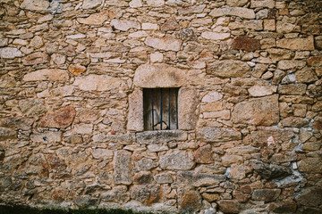 horizontal background of a stone wall with small window in the middle