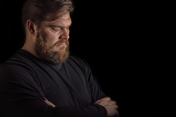 Close-up face profile portrait strong serious brutal bearded man on black. Confident and dramatic concept