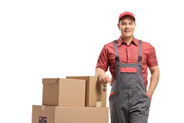 Delivery man leaning on a stack of boxes loaded on a hand truck
