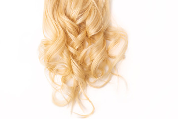 Human, natural light blond wavy hair on white isolated background. An example of a fashionable...