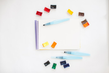 Bright stationery for drawing: paper, watercolor paints, brushes with a reservoir