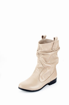 Beige Woman Long Boot Shoe Isolated on White Background. Fashionable boots for women may exhibit all the variations seen in other fashion footwear. Tapered or spike heels, platform soles, pointed toes