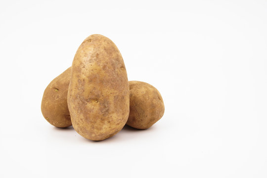 Three Raw Russet Potatoes Isolated On White Background