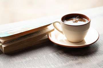 Cup of coffee with a book in coffee shop. Cozy concept 