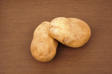 Russet potato with wooden texture background