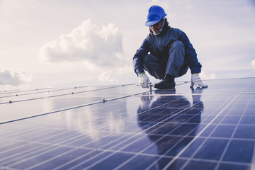 engineers repairing solar panel at generating power of solar power plant ; technician in industry...