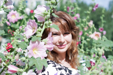 Fototapeta premium beautiful girl surrounded by colorful flowers mallow