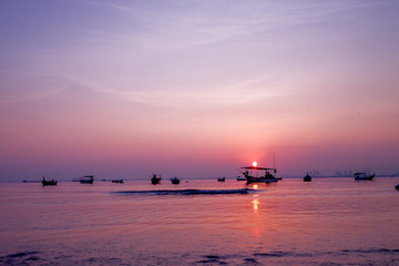 Beautiful sunrise on the beach and silhouette of fishing boat. Penang Malaysia