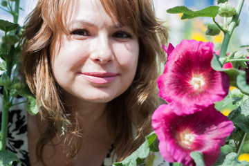 Naklejka premium beautiful girl surrounded by colorful flowers mallow