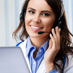 Smiling young doctor in headset, at office