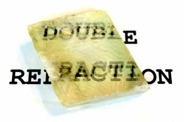 Double refraction of text in iceland spar crystal. Calcite specimen with optical birefringence.