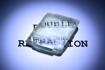 Double refraction of text in iceland spar crystal. Calcite specimen with optical birefringence.