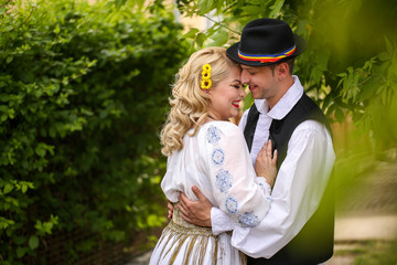 Beautiful couple posing outdoor in traditional clothes