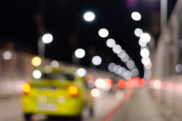 Defocused   city road   with multicolored  brightly glowing street lights and moving yellow taxi...