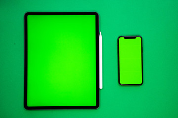 new tablet on a Green background with a keyboard and pen, and green screen top view