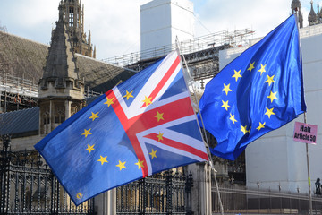 EU and UK flags flying together outside parliament in london