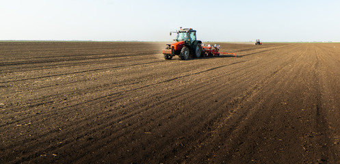 Fototapeta premium Farmer with tractor seeding soy crops at agricultural field
