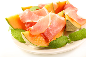 cantaloupe and prosicutto ham on white background