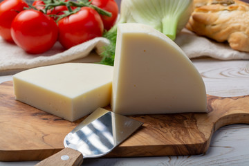 Italian cheese, Provolone dolce cow cheese from Cremona served with olive bread and tomatoes