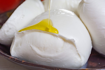 Balls and pieces of buffalo mozzarella, soft Italian scheese made from the milk of Italian Mediterranean buffalo