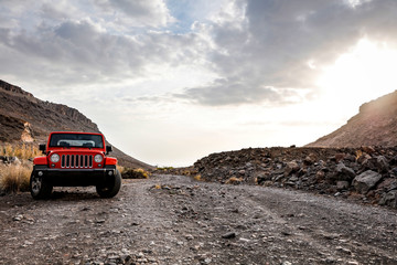 Red summer car on road . Gran Canaria island landscape. 