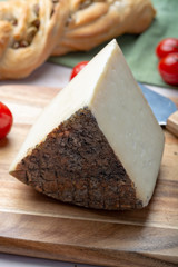 Italian cheese, piece of mature Tuscan Pecorino sheep cheese served with olive bread and tomatoes