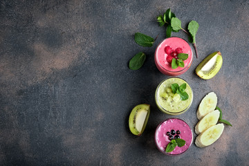 Fruit and berry smoothie blend at home against a dark background top view copy space.