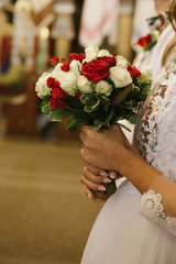 Obraz na płótnie Canvas closeup photo of Bride's hands holding bouquet in church
