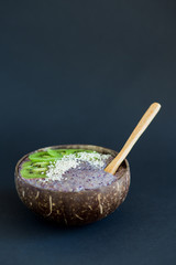 Healthy smoothie , plate made from coconut shell on dark background