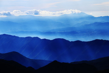 南アルプス塩見岳山頂から　光芒に煙る　恵那山　木曽遠景