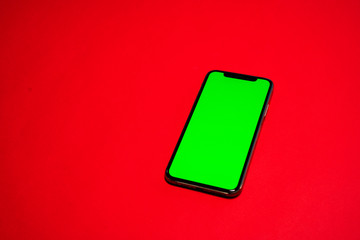 iPhone, Phone smartphone, green screen on Red background top view