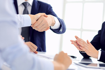 Group of business people or lawyers shaking hands finishing up a meeting , close-up. Success at negotiation and handshake concepts