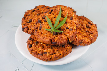 Delicious homemade Chocolate chip Cookies with CBD cannabis and leaf garnish and buds. Medicinal Edibles. Treatment of medical marijuana for use in food. Canada legalization. Rasta cookie recipe. 