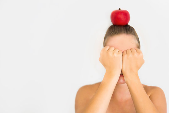 young woman with red apple on head