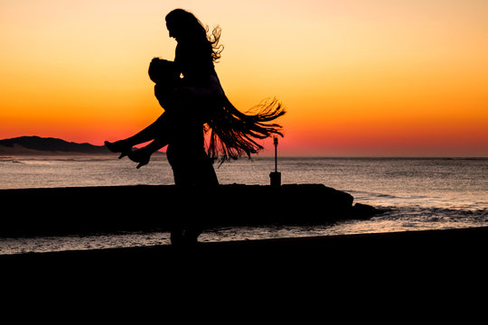 Couple dancing on the pier during sunrise make for awesome silhouettes