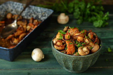 Baked mushrooms with balsamic vinegar in a rustic bowl on a wooden background
