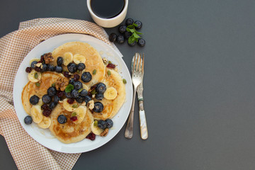 Freshmade, homemade pancakes with blueberry, dried fruits and honey. Breakfast with coffee and pancakes. Deliciious healthy food.
