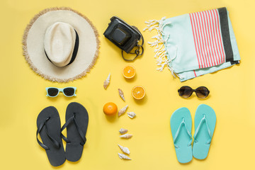 Beach accessories for two, straw beach sunhat,towel, sun glasses on yellow. Summer concept and...