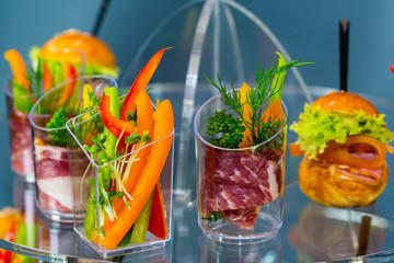 Mini canapes with cheese salads meat and seafood in plastic cups. 