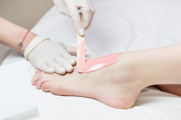 Woman in a beauty salon doing depilation 