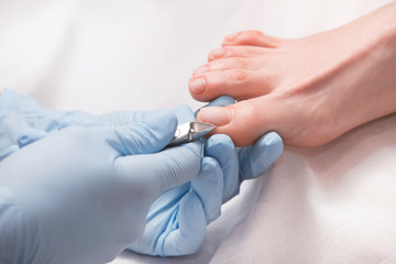 Process of pedicure of female legs at beauty salon