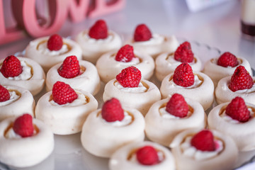 Marshmallows with raspberries, selective focus