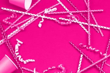 Party paper decorations and accessories in trendy neon pink monochrome party or celebration concept beyond plastic flat lay layout with copy space