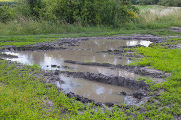 dirt road with puddle,rural roads in the summer after the rains with a large puddle