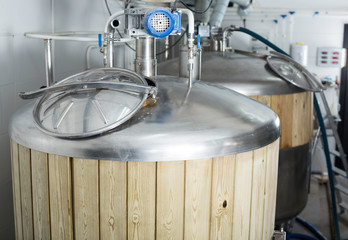 barrels with wood trimmed for beer fermentation lined in production hall
