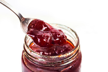 Jar of strawberry jam on  wooden background from top view