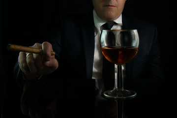 Businessman in a bar with a cigar and a glass of cognac