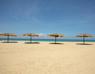 Straw umbrella on the beach for summer vacation tropics,Concept: Lifestyle for leisure travel,symbol tourism for island By the sea